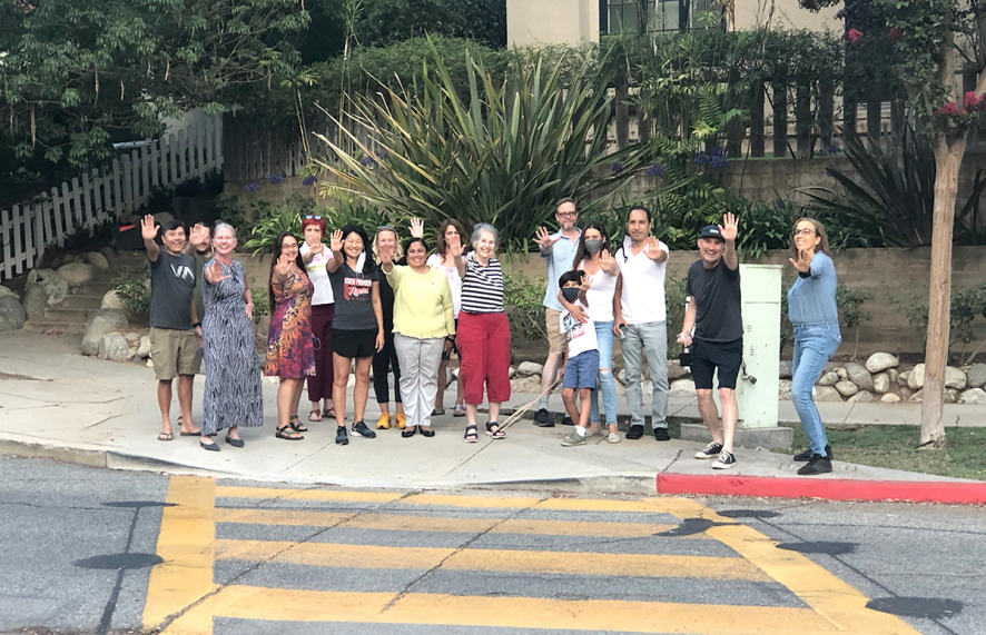 A crowd of people standing on a sidewalk